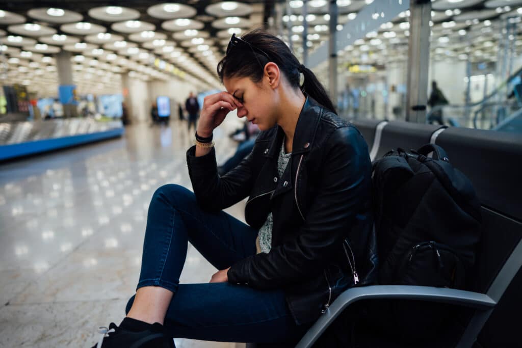 Frau mit Flugangst am Flughafen am warten